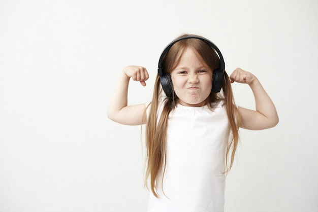 La bambina in cuffia. La bambina fa una smorfia. La bambina con i muscoli