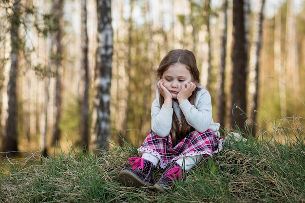 la bambina in natura è triste e annoiata