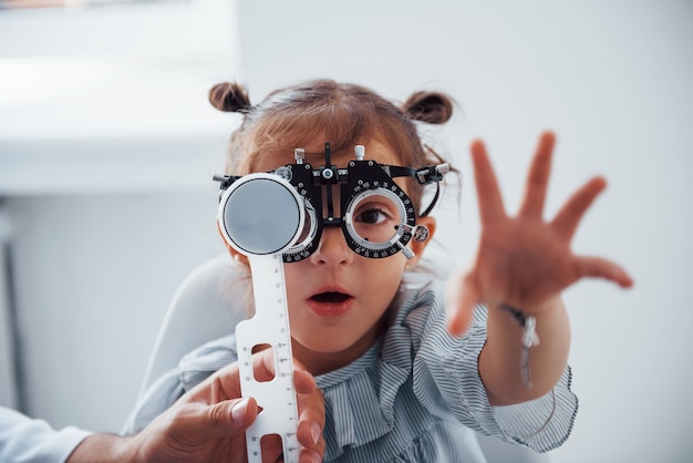 La bambina in occhiali nella clinica di oftalmologia ha il test della vista.