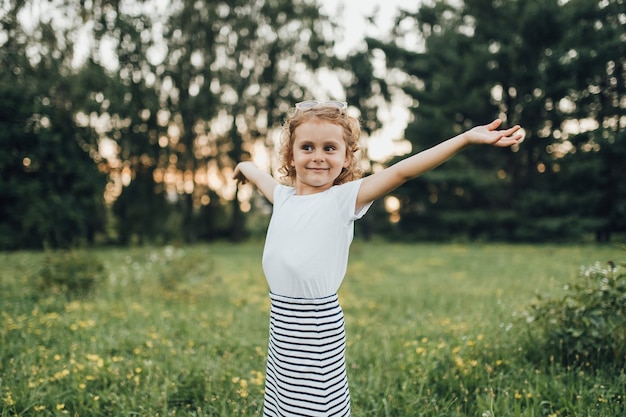 La bambina in vestito mostra all'aperto