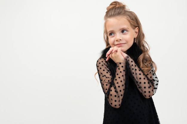 la bambina in vestito nero sta isolata su bianco