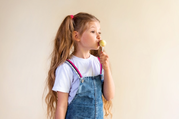 La bambina lecca il lecca-lecca.