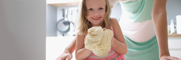 La bambina mostra la pasta e sorride