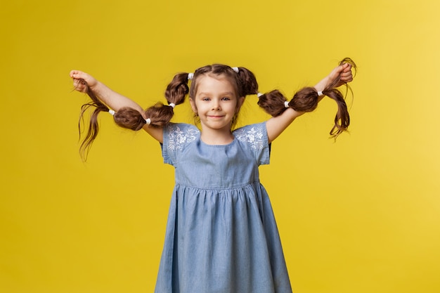 La bambina mostra trecce sane molto lunghe.