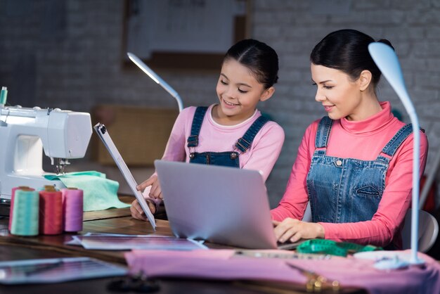 La bambina mostra una donna adulta uno schema di abbigliamento