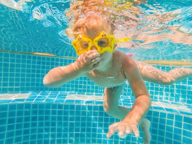 La bambina nuota abilmente sott'acqua in piscina