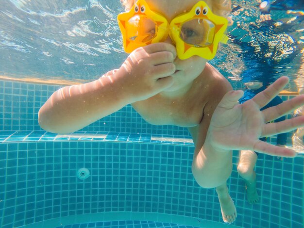 La bambina nuota abilmente sott'acqua in piscina