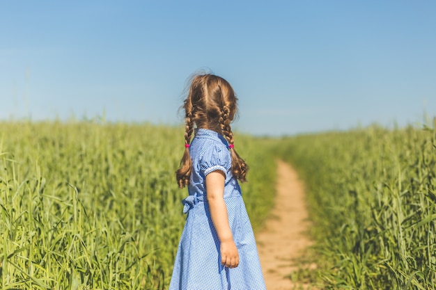 la bambina osserva in lontananza. vista da dietro