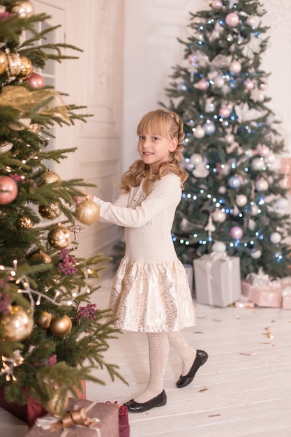 La bambina passa il tempo a decorare l'albero di Natale