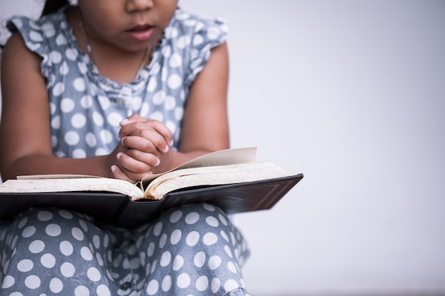 La bambina prega con una Sacra Bibbia