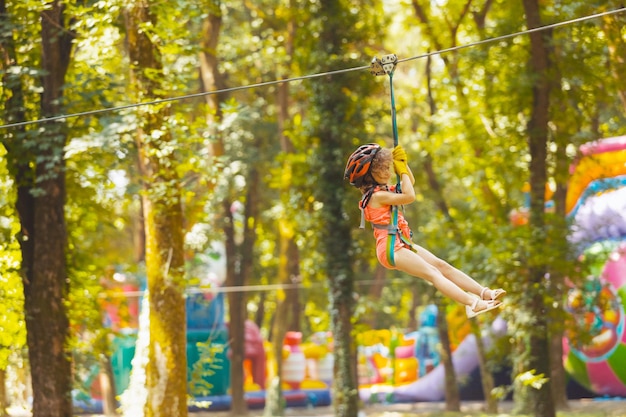 La bambina scende la zipline nel parco