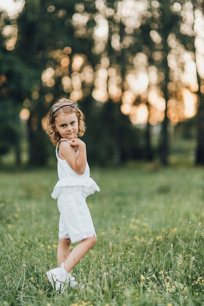 La bambina sembra bellissima nel parco al tramonto