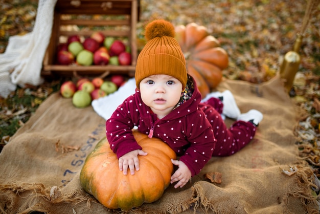 La bambina si appoggia su una zucca.