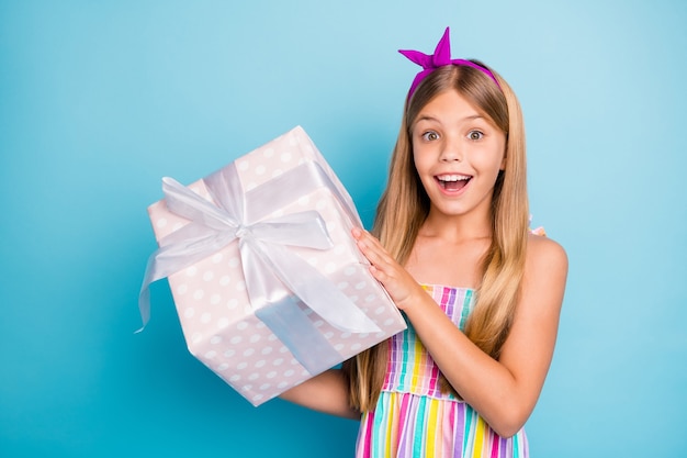 la bambina si gode la festa di compleanno tiene in mano una grande confezione regalo