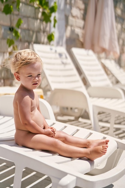 La bambina si siede su un lettino