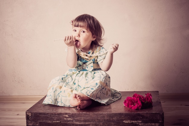 La bambina si siede su una vecchia valigia