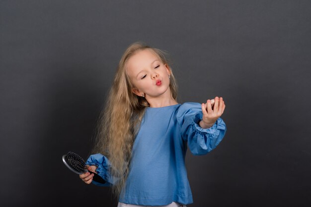 La bambina si spazzola i capelli aggrovigliati dopo la doccia, girato in studio