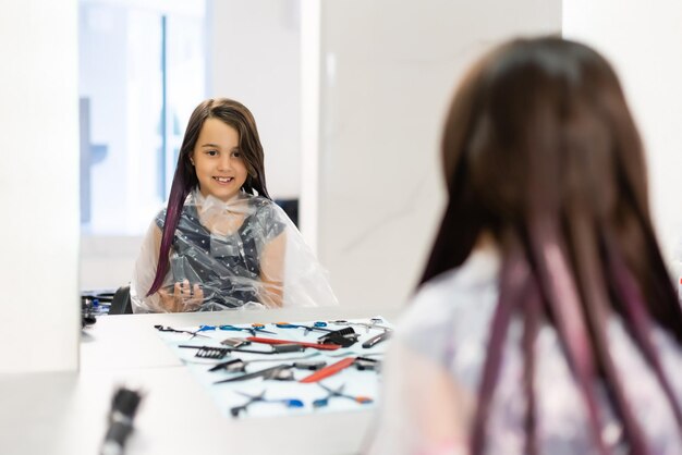 la bambina si tinge i capelli di viola in un parrucchiere