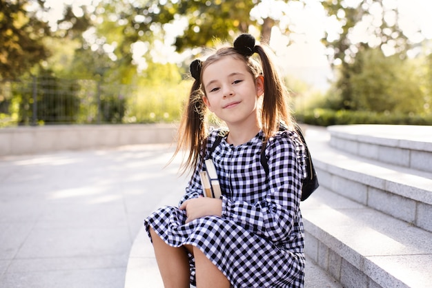 La bambina sorridente indossa un vestito bianco e nero a scacchi