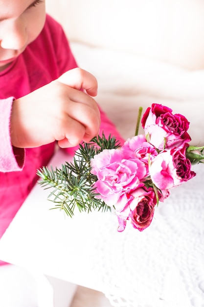 La bambina sta annusando le rose. Viso da vicino