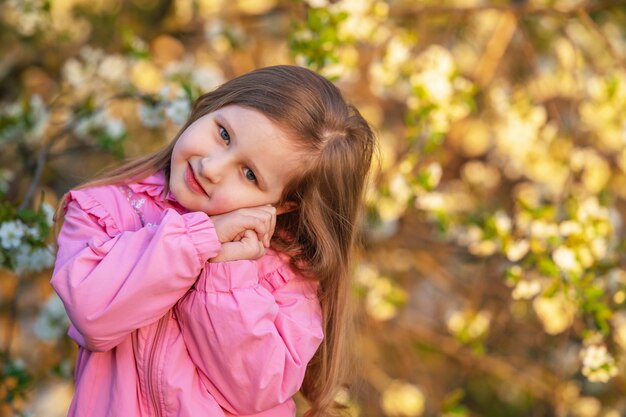 La bambina sta con le mani incrociate sotto la guancia