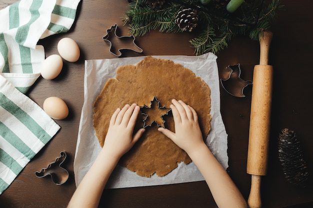 La bambina sta cuocendo i biscotti del pan di zenzero di natale.