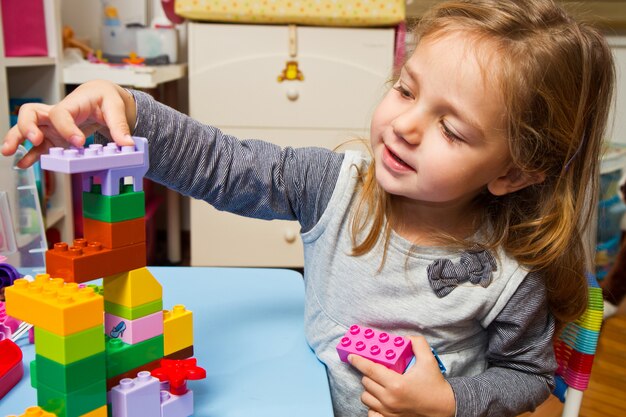 La bambina sta giocando con i mattoni da costruzione