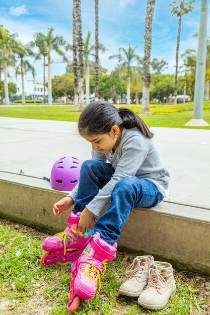 La bambina sta mettendo i suoi pattini a rotelle