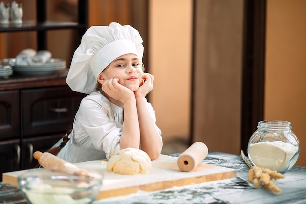 La bambina sta preparando la pasta in cucina.