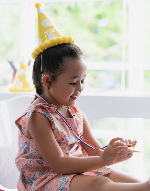 La bambina sta tenendo la medaglia d&#39;oro per il premio degli studenti