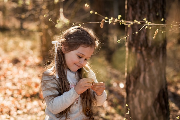 la bambina sulla natura esamina le piante