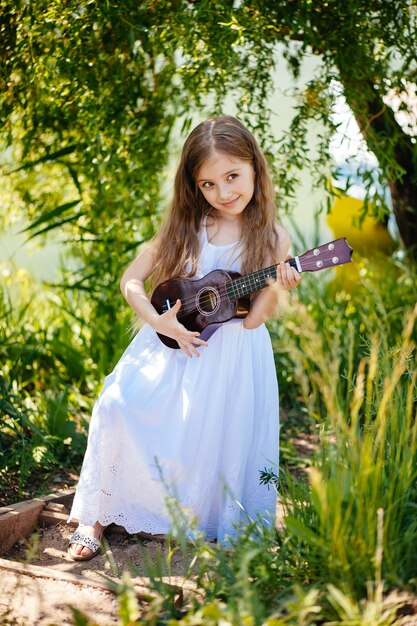 La bambina suona una piccola chitarra