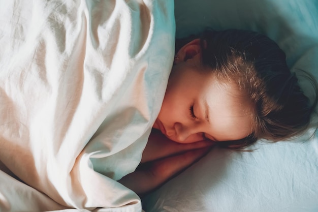 La bambina sveglia del bambino dorme nel letto