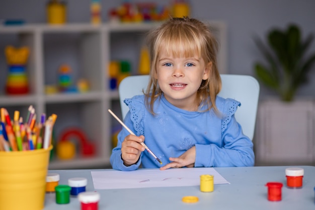 La bambina sveglia disegna con le vernici all'asilo