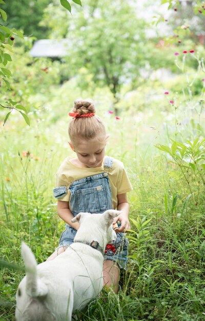 La bambina sveglia raccoglie una ciliegia da un albero nel giardino dei ciliegi