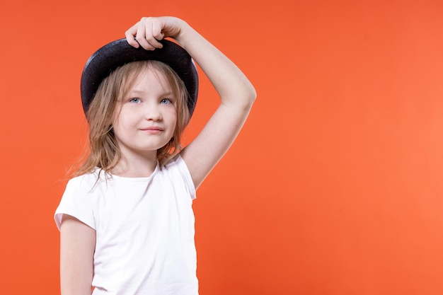 La bambina sveglia si mette un cappello nero in testa