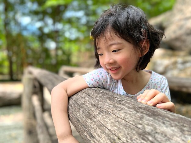 La bambina sveglia sorride nel giardino con lo spazio della copia