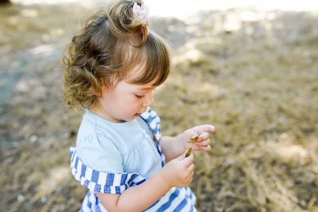 La bambina sveglia sta giocando con le foglie nel parco di autunno