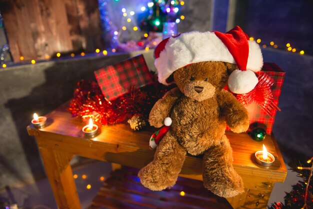 La bambola dell'orsacchiotto indossa il cappello di Natale per decorare lo sfondo di Natale
