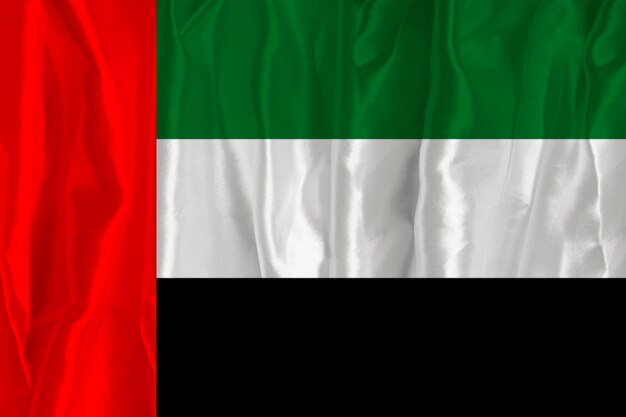 La bandiera degli Emirati Arabi Uniti su uno sfondo di seta è un grande simbolo nazionale Trama dei tessuti Il simbolo ufficiale dello stato del paese