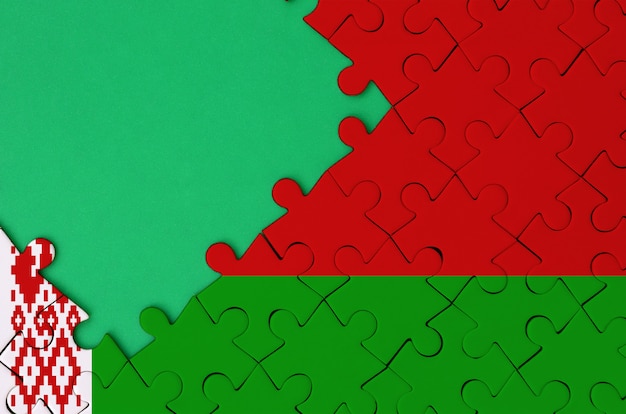 La bandiera della Bielorussia è raffigurata su un puzzle completato con spazio verde libero sul lato sinistro