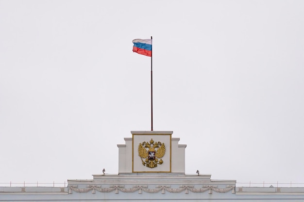 La bandiera e lo stemma della Federazione Russa sull'edificio amministrativo Messa a fuoco selettiva
