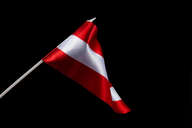 La bandiera lettone su sfondo nero si sta sviluppando e volando nel vento