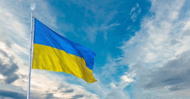 La bandiera nazionale ucraina si disperde nel vento. Bandiera dell'Ucraina sul cielo blu. Banner o sfondo ucraino. illustrazione