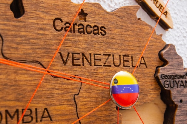 La bandiera venezuelana sul perno con filo rosso mostrava i percorsi sulla mappa in legno