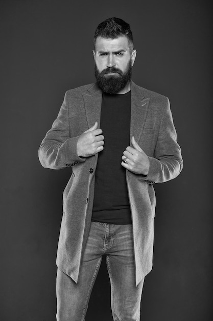 La barba rende l'uomo più brutale Uomo alla moda su sfondo grigio L'uomo hipster barbuto indossa abbigliamento casual Uomo caucasico con lunghi baffi e barba
