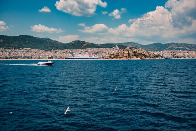 La barca degli aliscafi scorre attraverso l'acqua di fronte alla città di Kavala