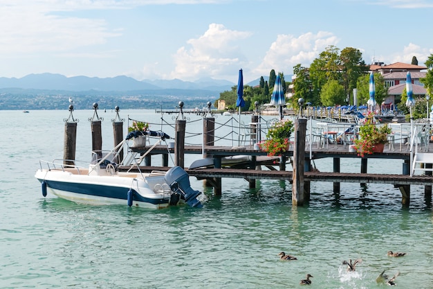 la barca galleggia in acqua in un molo di legno sulla riva della località turistica