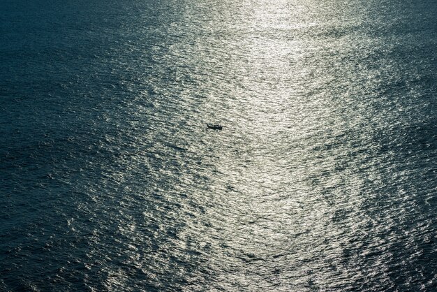 La barca naviga al tramonto nell'oceano.