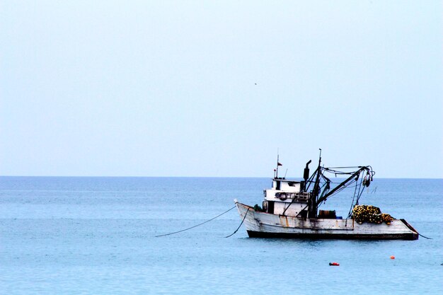 La barca ormeggiata nel calmo mare blu